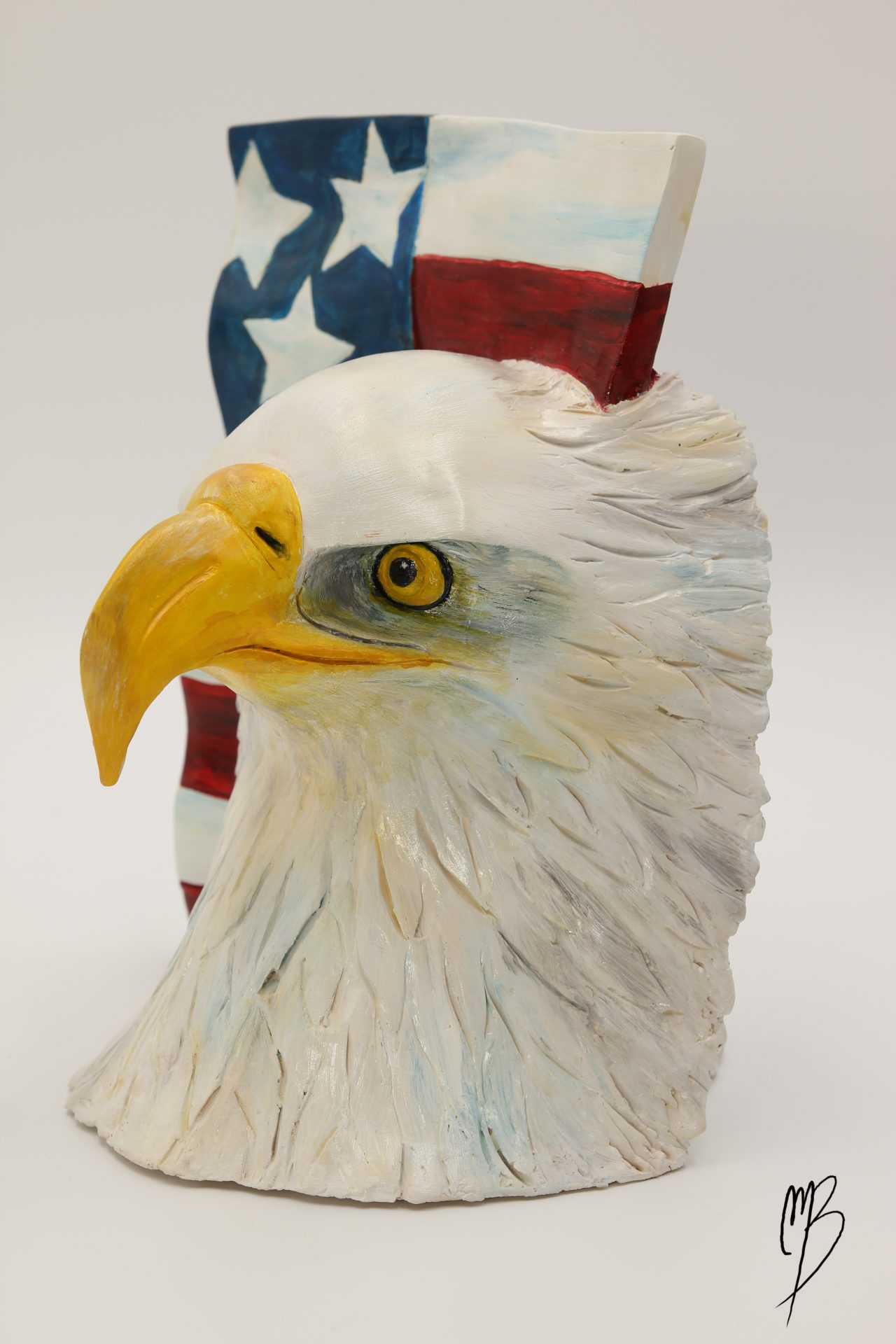Sculptures. Animaux. Tête d'aigle et drapeau américain en terre cuite recouverts de peinture acrylique vernie.