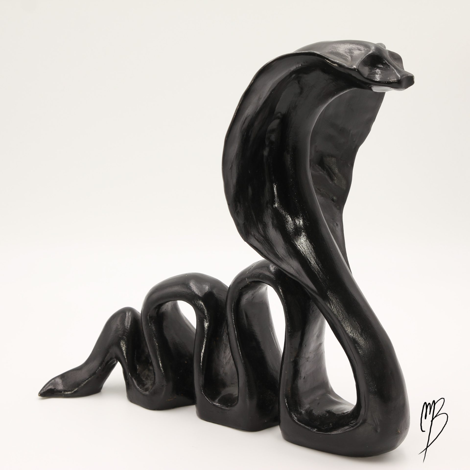 Animaux. Cobra prêt à attaquer en terre cuite recouverts de peinture acrylique noire vernie. Vue de côté.