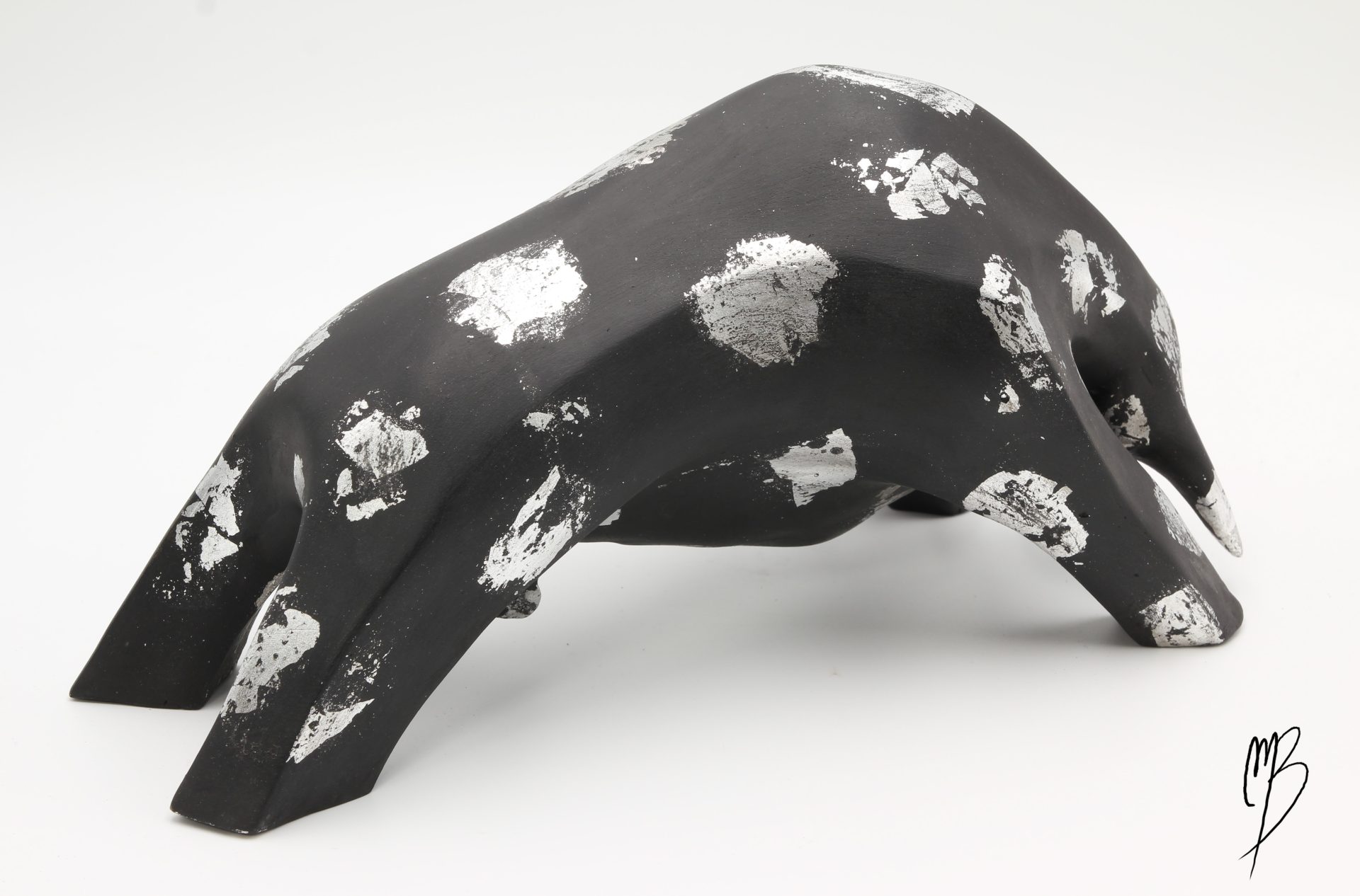 Animaux. Taureau noir en terre cuite recouvert de peinture acrylique et de feuilles d'argent. Vue de dos.