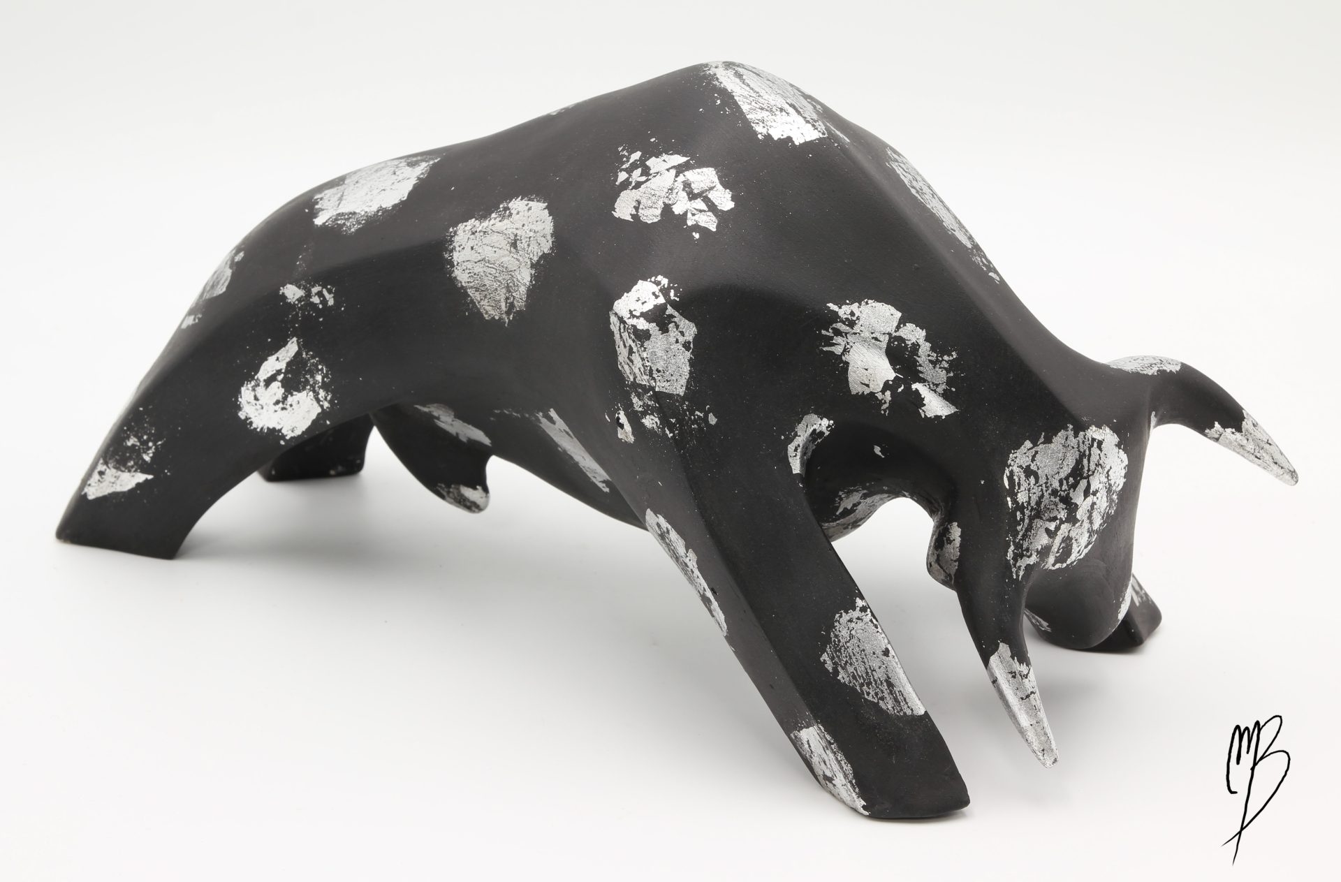 Animaux. Taureau noir en terre cuite recouvert de peinture acrylique et de feuilles d'argent. Vue de côté