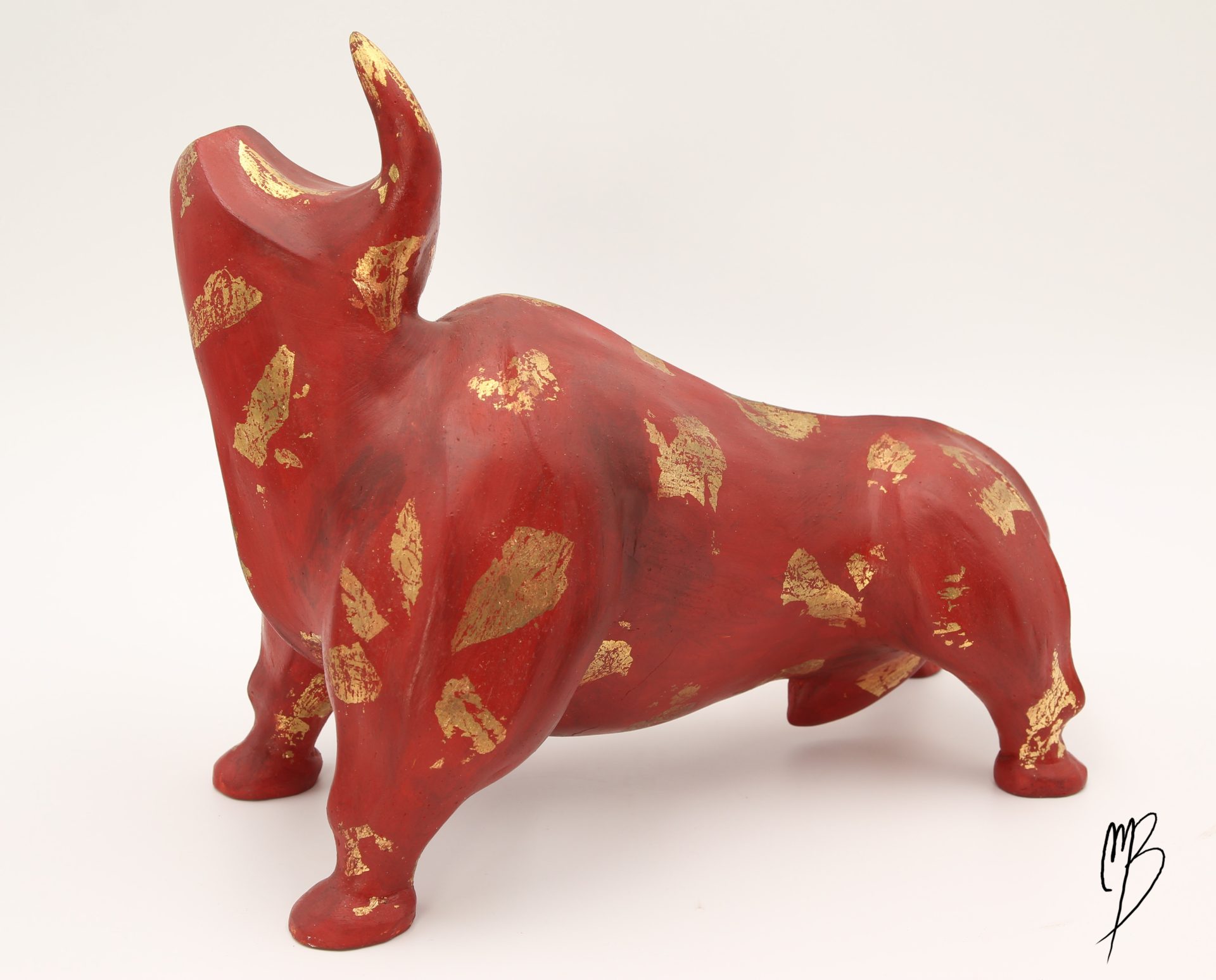 Sculptures. Animaux. Taureau rouge en terre cuite recouvert de peinture acrylique et de feuilles d'or. Vue de côté.