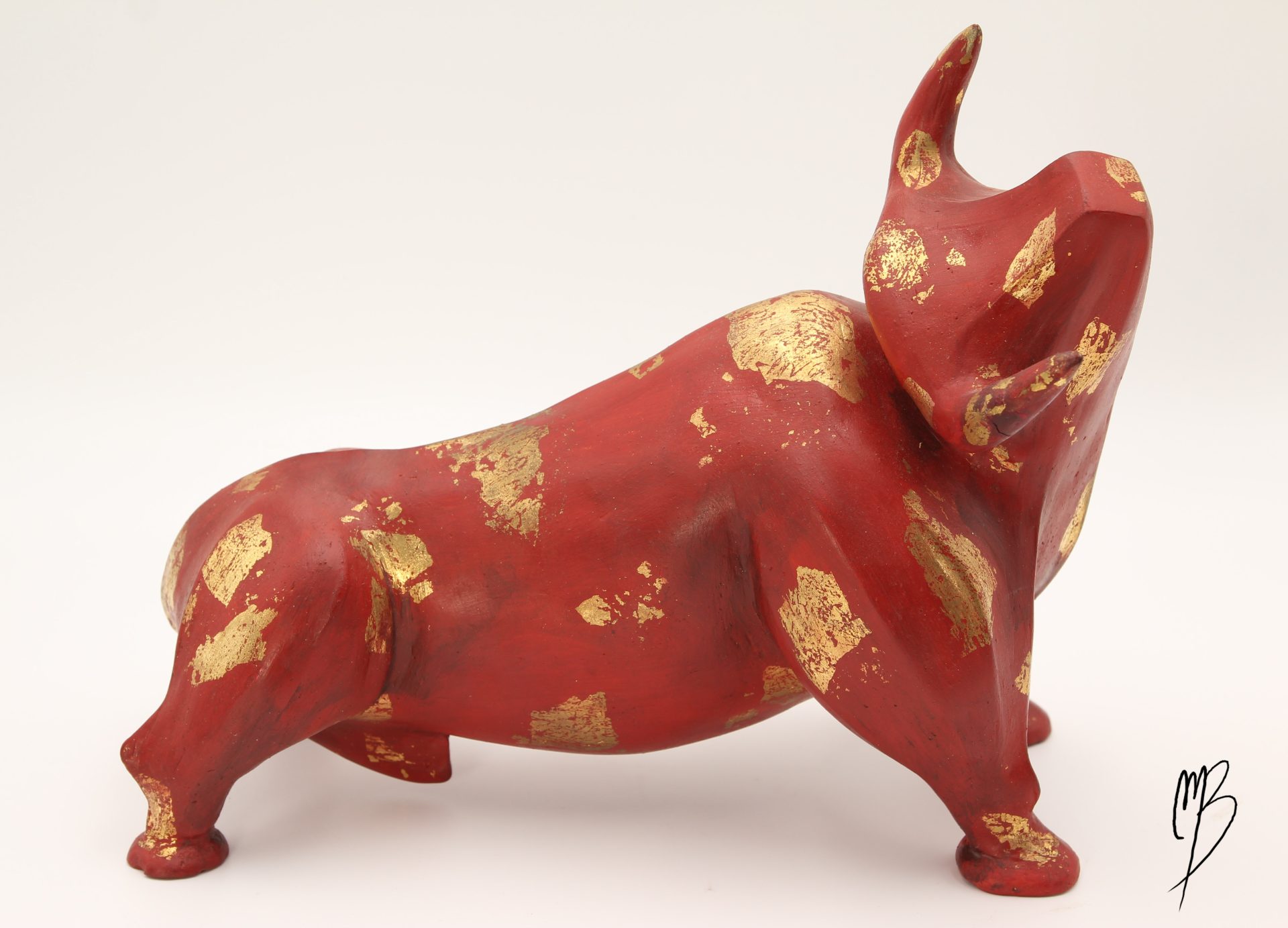 Animaux. Taureau rouge en terre cuite recouvert de peinture acrylique et de feuilles d'or. Vue de côté.
