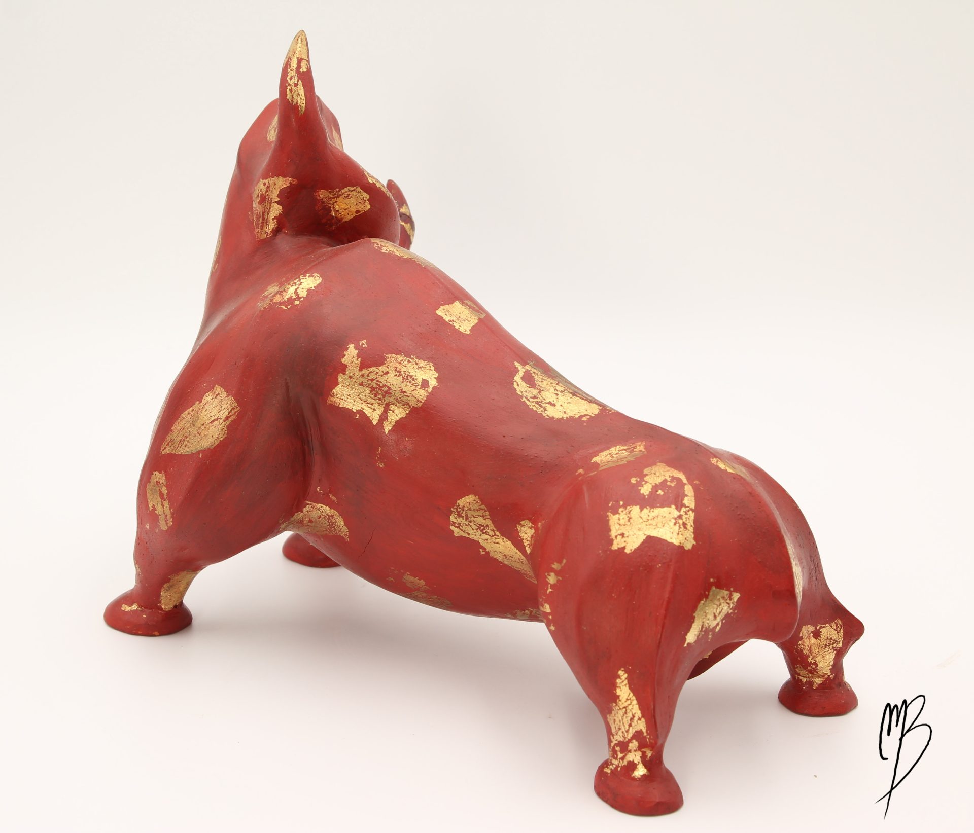 Animaux. Taureau rouge en terre cuite recouvert de peinture acrylique et de feuilles d'or. Vue de dos.