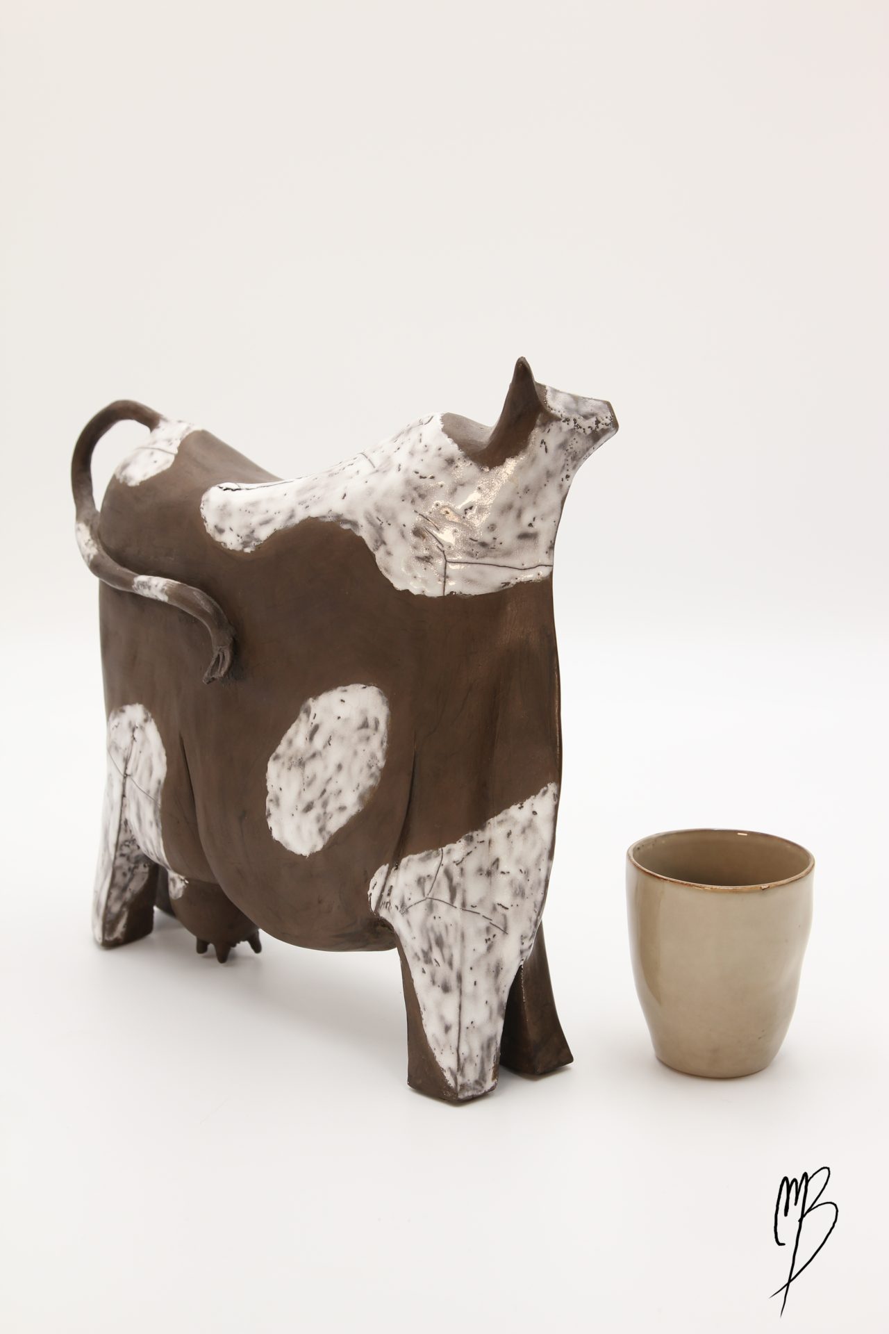 Sculptures. Animaux. Vache stylisée marron en terre cuite avec des tâches blanches émaillées.