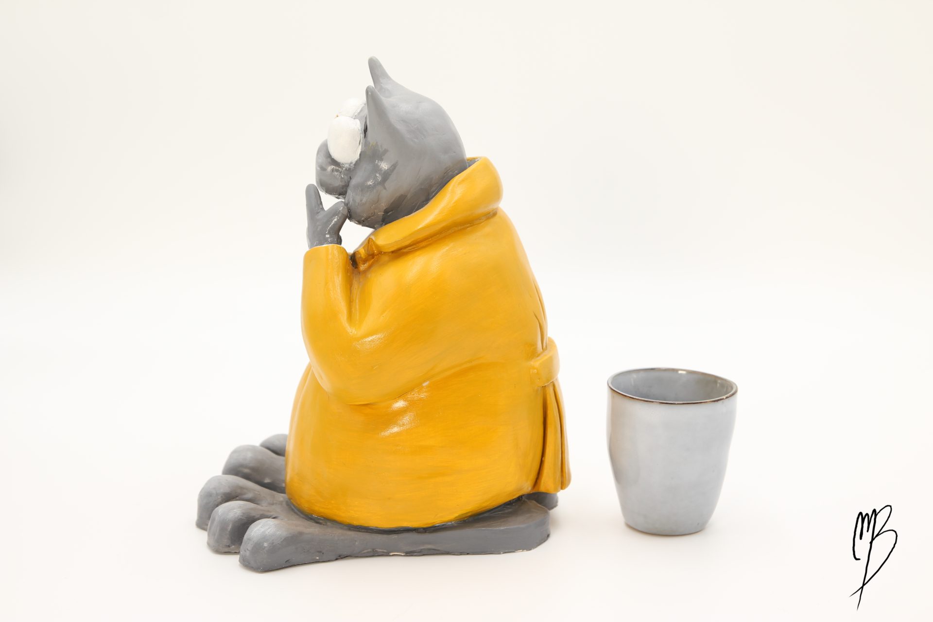 Bande dessinée. Le Chat debout habillé d'un ciré jaune en terre cuite recouverte de peinture acrylique vernie vue de côté