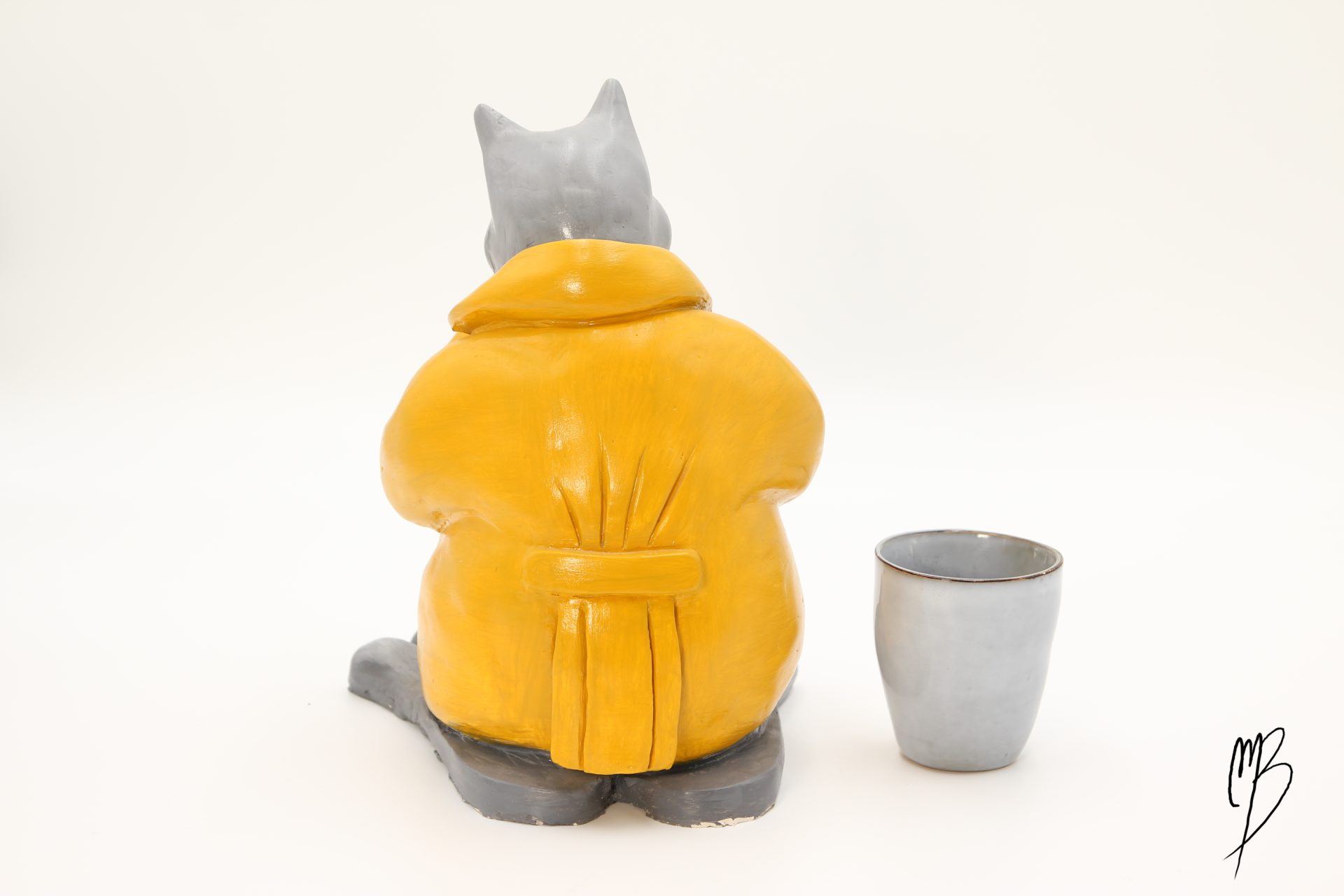 Bande dessinée. Le Chat debout habillé d'un ciré jaune en terre cuite recouverte de peinture acrylique vernie vue de dos