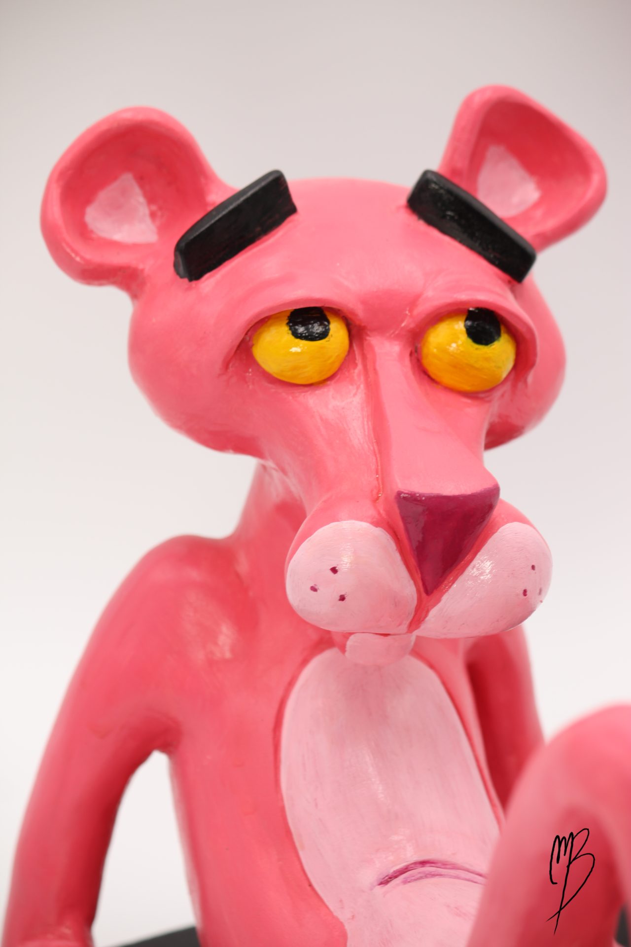 Bande dessinée. Panthère Rose allongée sur un socle en terre cuite recouverte de peinture acrylique vernie vue de détail sur la tête
