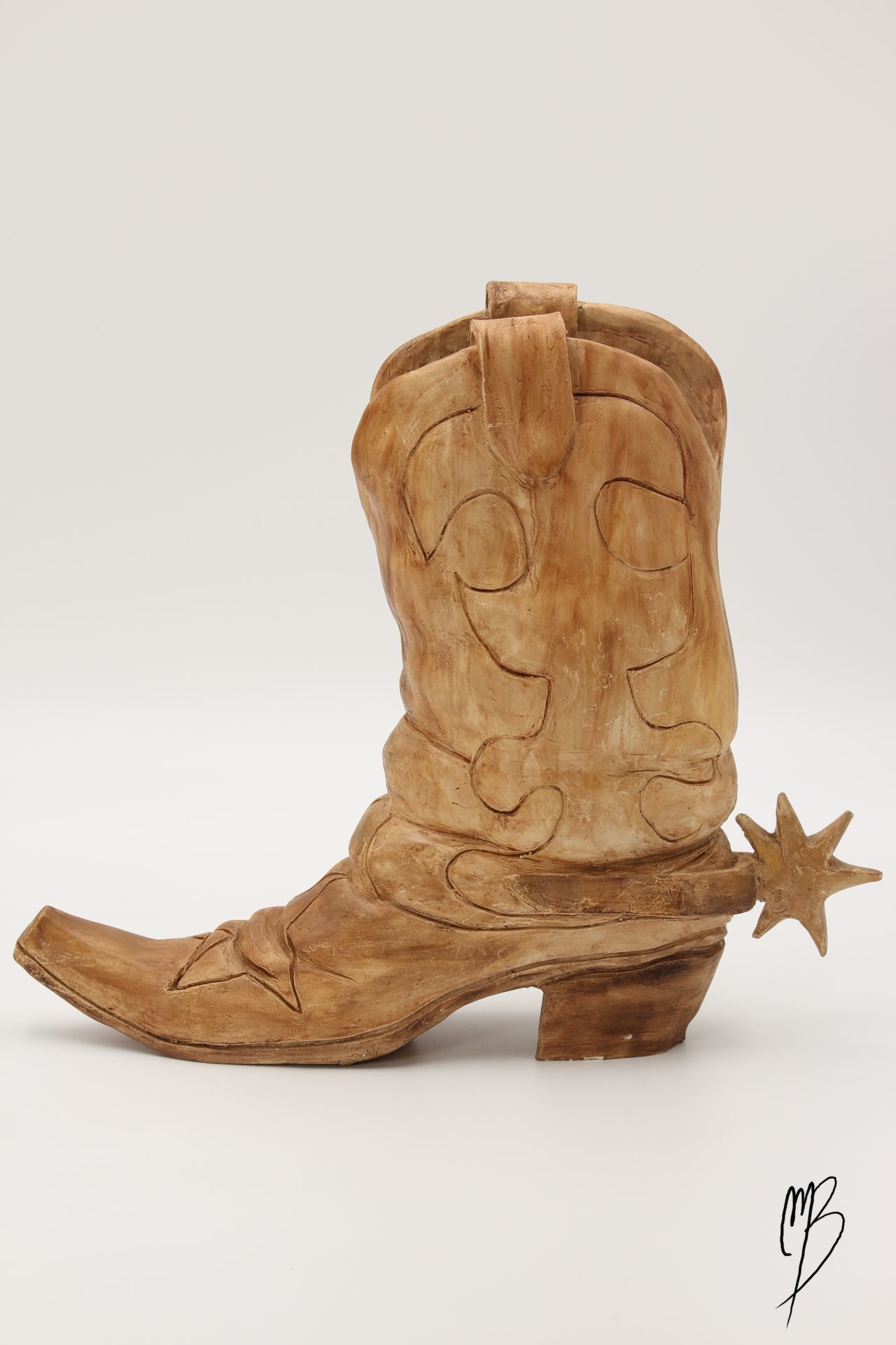 Botte de cowboy Santiag avec son éperon en terre cuite patinée avec une peinture acrylique ocre terre du désert. Vue de côté