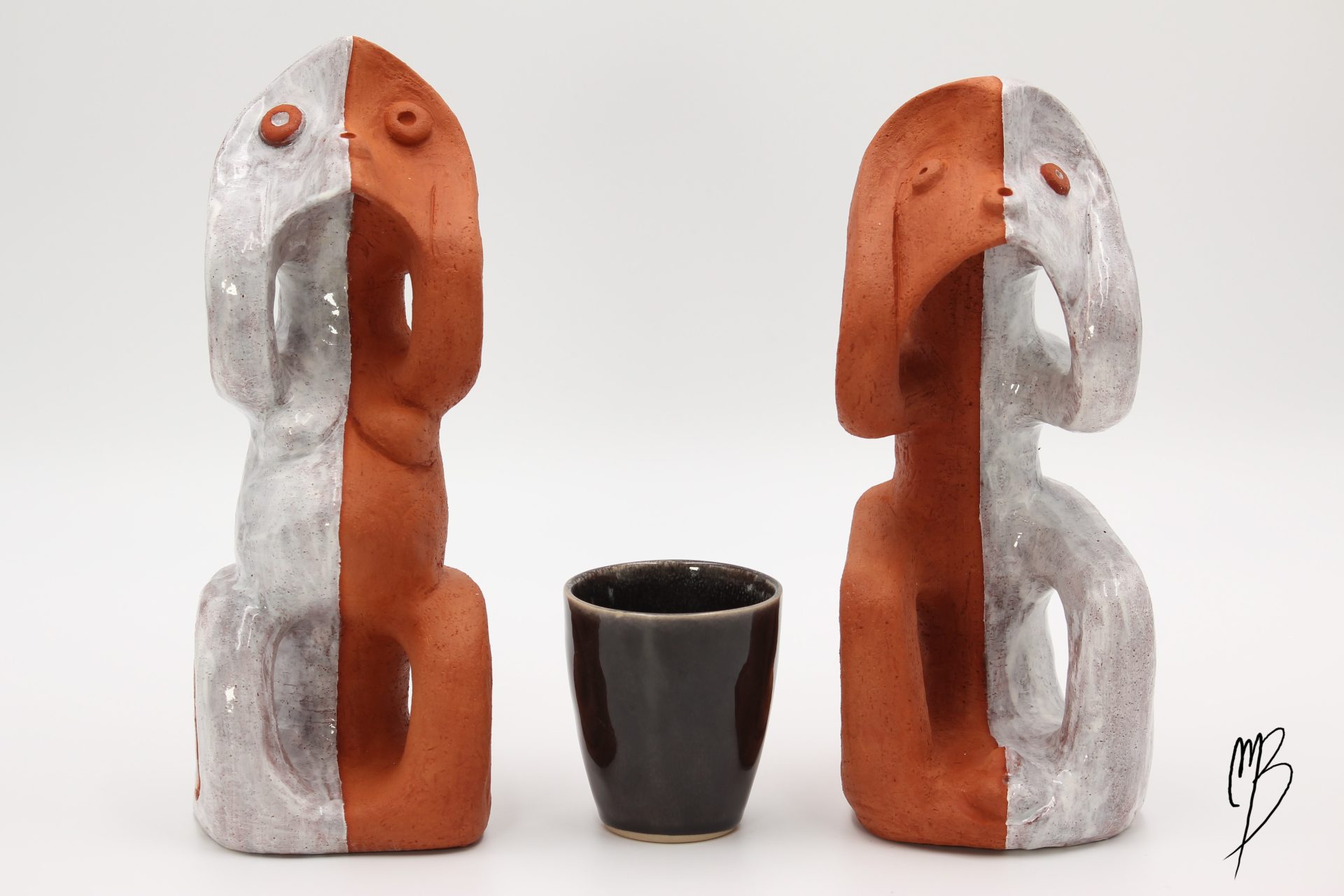 Couple Maya en Terre cuite avec des parties blanches émaillées pièces se faisant face. Vue de face bicolore blanc émaillé et terre cuite, comparé à une tasse pour la taille.
