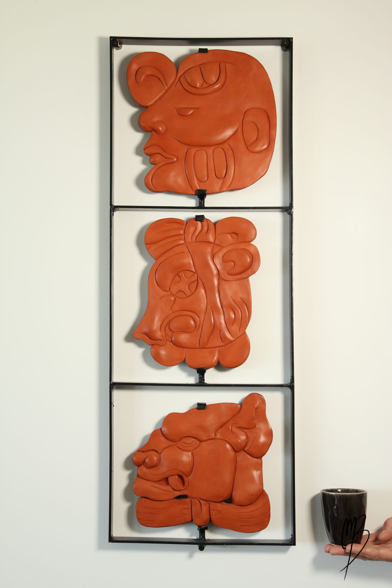 Glyphe, modelages sculptures composé de trois têtes Maya en terre cuite cirées sur cadre métal, vue générale de face
