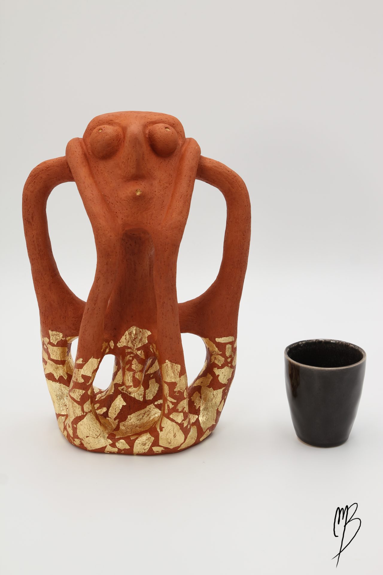 Mâle Maya en Terre cuite recouvert de feuille d'or sur la partie basse de la sculpture. Vue de face comparative à une tasse pour la taille.