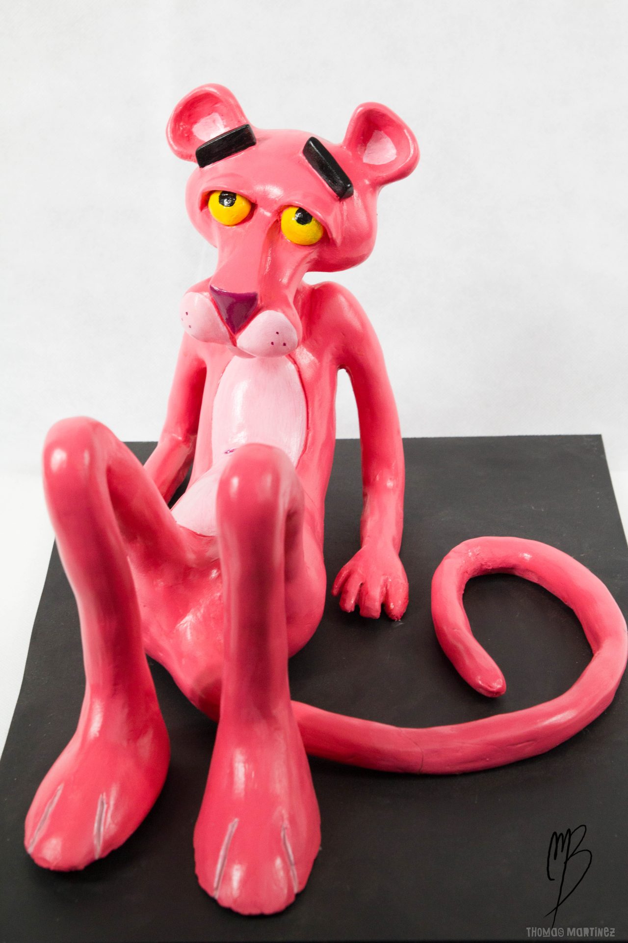 Sculptures. Bande dessinée. Panthère Rose allongée sur un socle en terre cuite recouverte de peinture acrylique vernie