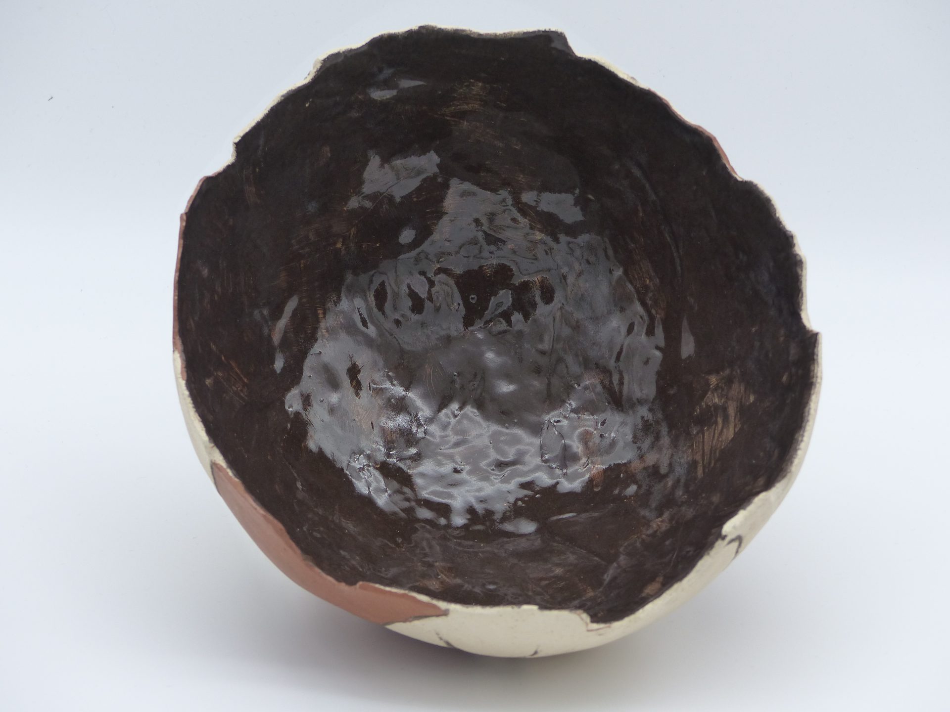 demie coupe façon poterie antique brisée, posée sur trois petits pieds, en terre cuite, avec l'intérieur émaillé noir, et l'extérieur bicolore marron et beige ciré, vue de dessus
